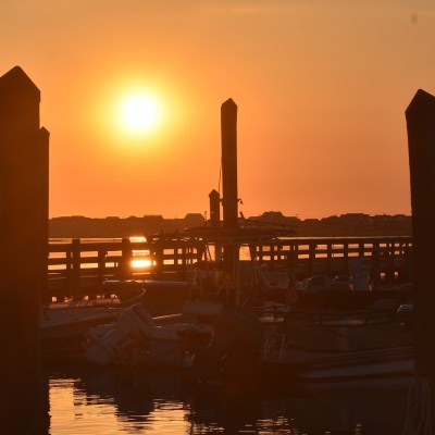 a sunset over a body of water with a city in the background